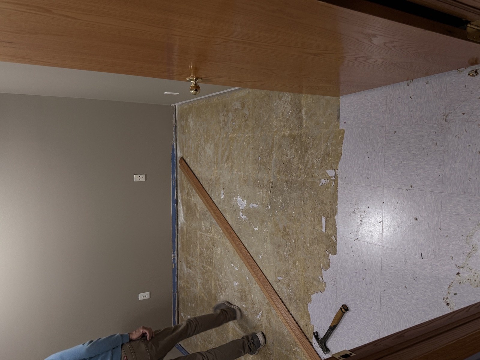 Old vinyl tile and carpet pad being pulled from the floor