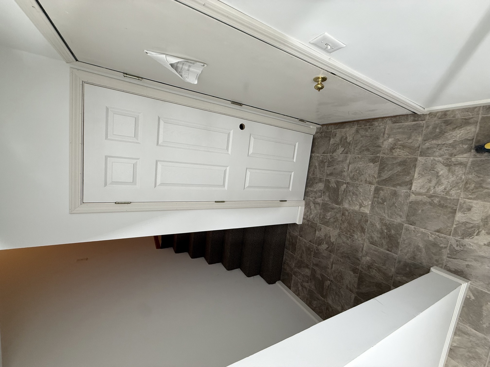 Finished entry with new tile and carpeted stairs