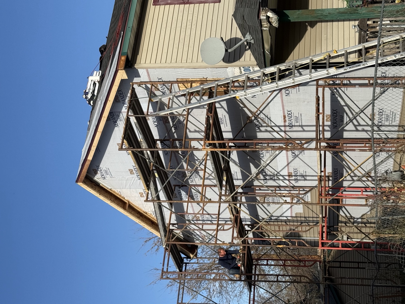 Home exterior with scaffolding during siding and roof work